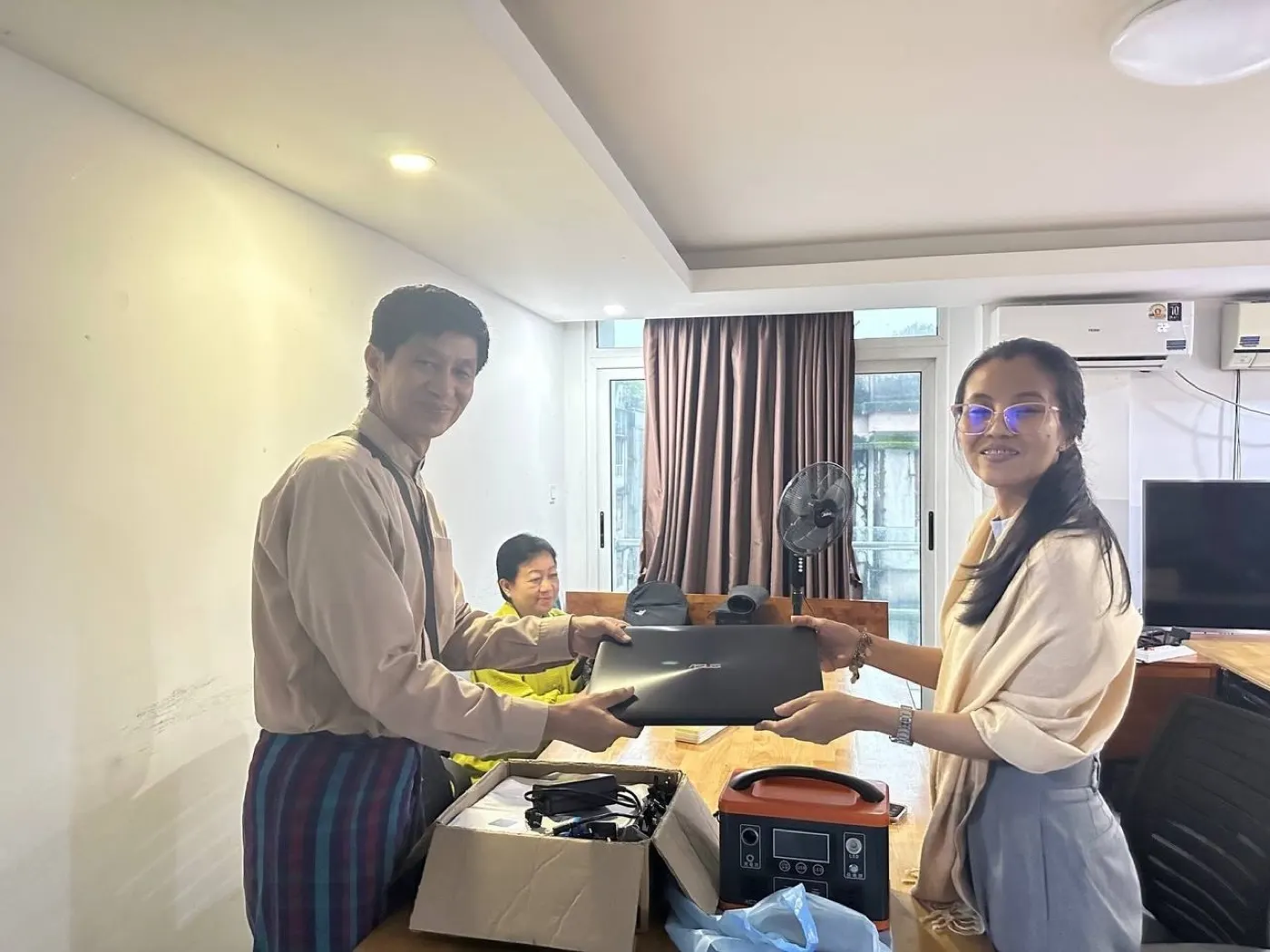 Laptops and a backup power station being handed over