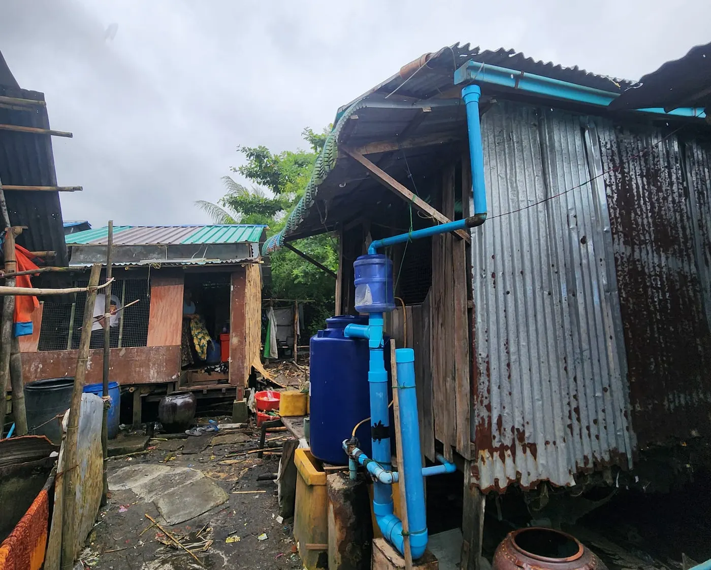 A repaired house with a blue rainwater storage tank